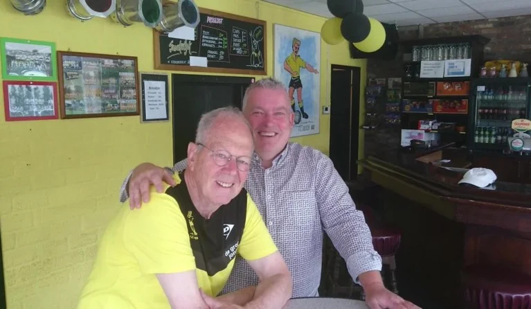 Johnny Curfs en Joop Delissen, vaste vrijwilligers van FC Gulpen, samen in de geel-zwart versierde kantine