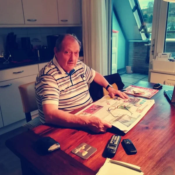 Erelid Sjef Jongen van FC Gulpen, oud-penningmeester en bestuurslid, leest de krant aan zijn keukentafel