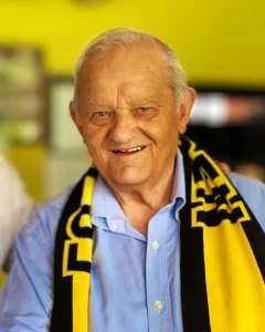 Hub Schols, erelid en oud-speler van FC Gulpen, draagt een geel-zwarte clubsjaal - in memoriam 1933-2025